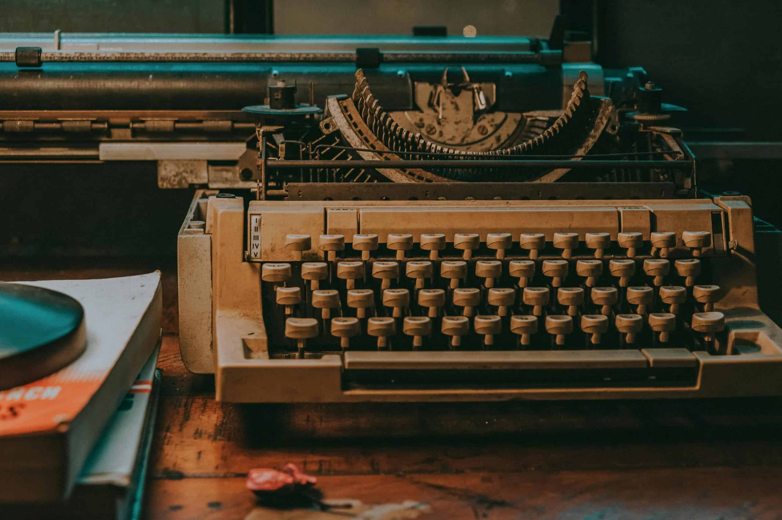 Close-up of a vintage typewriter on a wooden desk with classic design elements. Blog post on technology and progress.